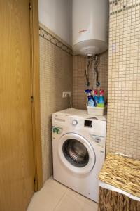 a laundry room with a washing machine and a light at Apartament al cor del barri vell de Girona in Girona