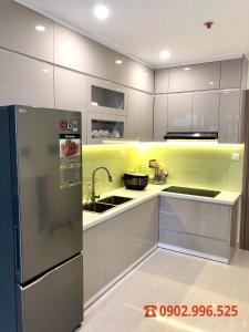 a kitchen with white cabinets and a refrigerator at Vinhomes Grand Park Quận 9-Bống House in Long Bình