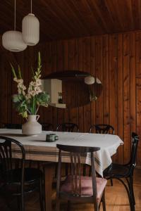une table à manger avec des chaises et un vase de fleurs dans l'établissement Dzikosc Orlowiec, à Lądek-Zdrój