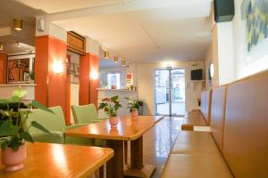 ein Restaurant mit Holztischen und grünen Stühlen in der Unterkunft Hotel Deutschmeister in Wien