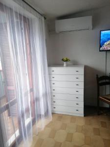 a bedroom with a dresser and a window at Аppartamenti vicino al mare in Scalea