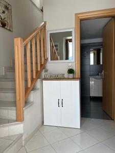 a bathroom with a staircase and a white cabinet with a mirror at Lagom House in Panagia