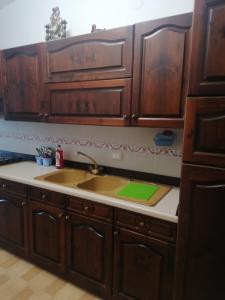 a kitchen with wooden cabinets and a sink at Аppartamenti vicino al mare in Scalea