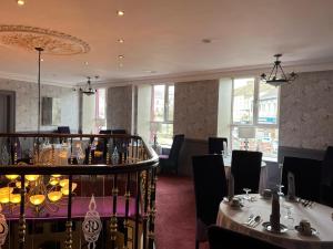 a dining room with two tables and chairs and windows at Central Hotel Donegal in Donegal