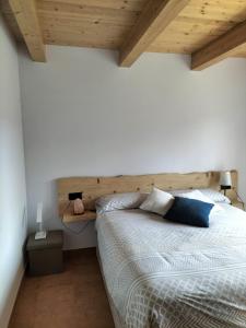 1 dormitorio con 1 cama grande y cabecero de madera en CA L'ANELLA (SALDES), en Saldes