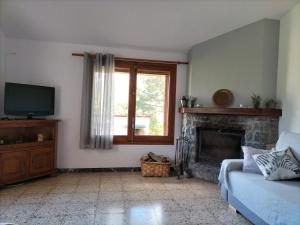 a living room with a couch and a fireplace at CA L'ANELLA (SALDES) in Saldés