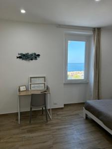 een slaapkamer met een bed, een bureau en een raam bij Stella di Mare in Civitavecchia