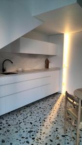 a kitchen with white cabinets and a table and a chair at CASA dos MIÑOS in Cangas de Morrazo