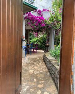 una puerta abierta a un patio con flores púrpuras en Apartman Mafini en Krasići