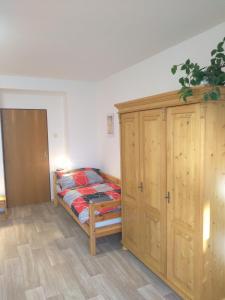 um quarto com uma cama e um armário de madeira em Hrnčírna em Kněževes