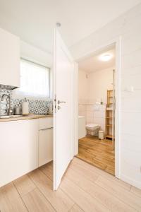 a kitchen with a door open to a bathroom at Apartamenty Tęsknoty 10 in Dziwnów
