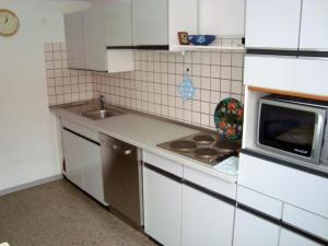una piccola cucina con lavandino e forno a microonde di Wachholz, Ferienwohnung a Celle