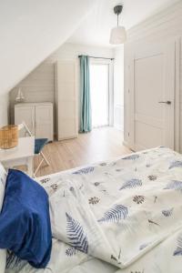 a bedroom with a large bed with blue sheets at Apartamenty Tęsknoty 10 in Dziwnów