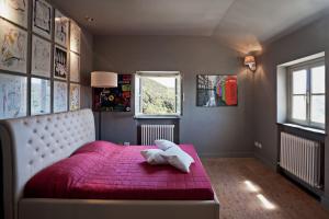 Villa Margherita appartamento per 5 in Villa ottocentesca في Castiglione Chiavarese: غرفة نوم بسرير احمر مع بطانية حمراء