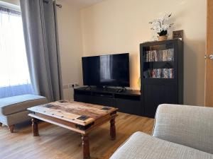 ein Wohnzimmer mit einem TV und einem Couchtisch in der Unterkunft Apartment 3 in Holyhead