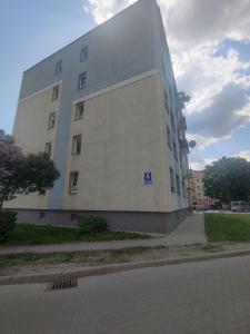 a large white building on the side of a street at Apartament Heaven in Ełk