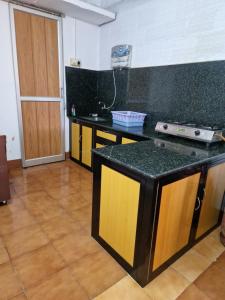a kitchen with a black and yellow counter top at Gladsvilla in Mangalore
