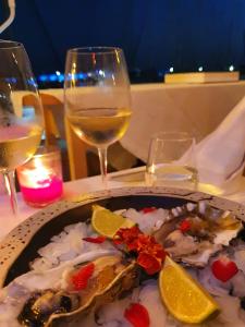 a plate of food on a table with glasses of wine at Very Romantic Seaview Apartment Patalavaca Mogán with Warm Pool in Patalavaca +21 photos