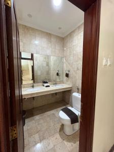 La salle de bains est pourvue de toilettes, d'un lavabo et d'une baignoire. dans l'établissement KUTA - 4BR Villa with Private XL Pool, à Kuta