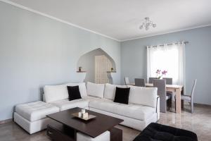sala de estar con sofá blanco y mesa en Old Port Spetses Mansion en Spetses