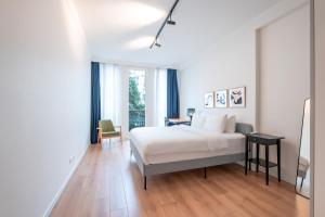 a white bedroom with a bed and a desk and a chair at Homie Suites - Luxury Apartments in Maçka in Istanbul