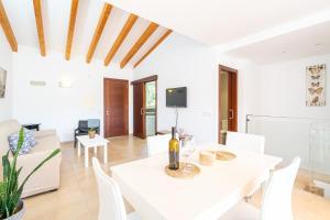 Apartament Cala Anguila في ماناكور: غرفة طعام بيضاء مع طاولة بيضاء وكراسي