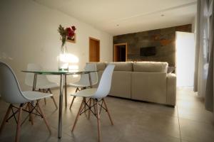 een woonkamer met een glazen tafel en witte stoelen bij Hacienda Laguna Seca - Apart. Hibisco in Chiclana de la Frontera