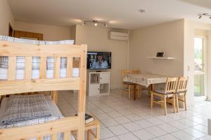 a bedroom with a bunk bed and a dining room with a table at Ferienwohnung beim Europa-Park Rust in Rust