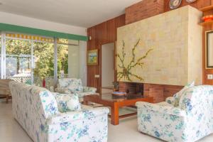 a living room with two chairs and a fireplace at Magnifica VILLA AIREOLA frente al mar in Benicàssim +30 photos