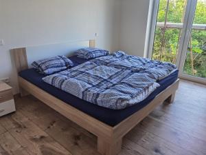 1 cama con edredón azul y almohadas en un dormitorio en Sunset House Piešťany Červená Veža en Banka