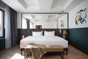 a bedroom with a large white bed and a table at Almanac X Alcron Prague in Prague