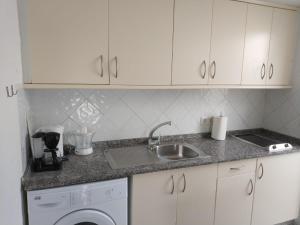 a kitchen with a sink and a washing machine at bungalow with private garden in Playa del Ingles