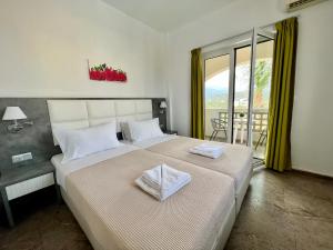 a bedroom with a large bed and a balcony at Maria Hotel Sisi in Sissi