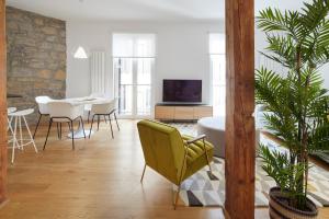 a living room with a yellow chair and a table at Salamanka by FeelFree Rentals in San Sebastián