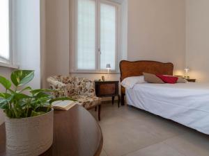 um quarto com uma cama, uma cadeira e uma mesa em Mamma Ciccia Holiday Home - Old Village Apartment em Mandello del Lario