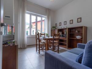 uma sala de estar com um sofá azul e uma mesa em Mamma Ciccia Holiday Home - Old Village Apartment em Mandello del Lario