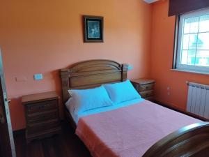 um quarto com paredes cor de laranja e uma cama com almofadas azuis em Casa Fina em Foz