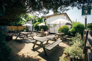 a group of picnic tables with umbrellas on a patio at The East End Arms in Lymington