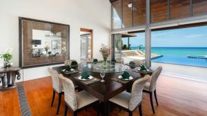 a dining room with a table and chairs and the ocean at Villa Viman in Kathu
