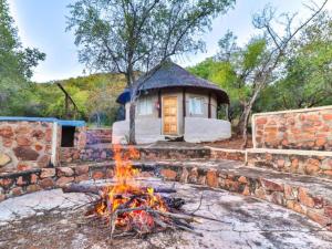 a fire pit in front of a small building at Thuto Centre Conferencing & Bush Lodge in Bela-Bela