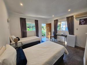 a hotel room with two beds and a desk at Thuto Centre Conferencing & Bush Lodge in Bela-Bela