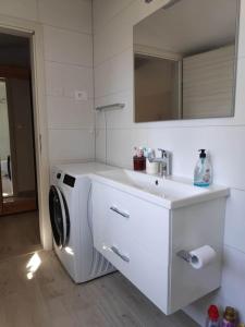 a white bathroom with a washing machine and a sink at Mala Villa in Kaštela