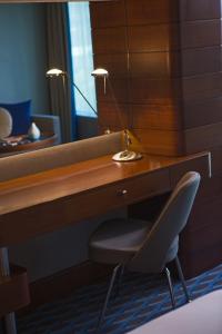 a desk with a chair and a desk with a mirror at Renaissance Izmir Hotel in Izmir