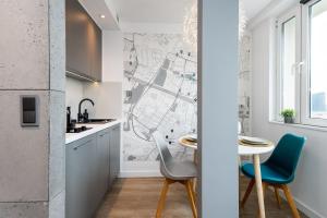 a kitchen with a table and chairs with a map on the wall at Kairos Apartments - Spodek - 100 m od Spodka in Katowice