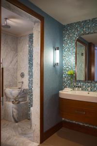 a bathroom with a tub and a sink and a mirror at Renaissance Izmir Hotel in İzmir