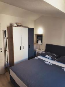 a bedroom with a blue bed and a white cabinet at Mala Villa in Kaštela