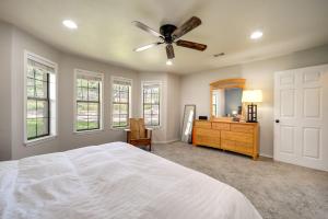 een slaapkamer met een wit bed en een plafondventilator bij Spacious Austin Vacation Rental with Deck! in Dripping Springs