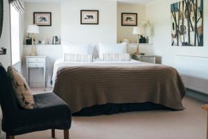 a bedroom with a bed and a chair at The East End Arms in Lymington +14 photos