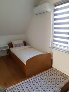 a small bed in a room with a window at Vila Haris in Sarajevo