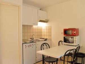 une petite cuisine avec une table et un four micro-ondes dans l'établissement Appartement Saint-Aygulf, 1 pièce, 4 personnes - FR-1-226A-89, à Saint-Aygulf